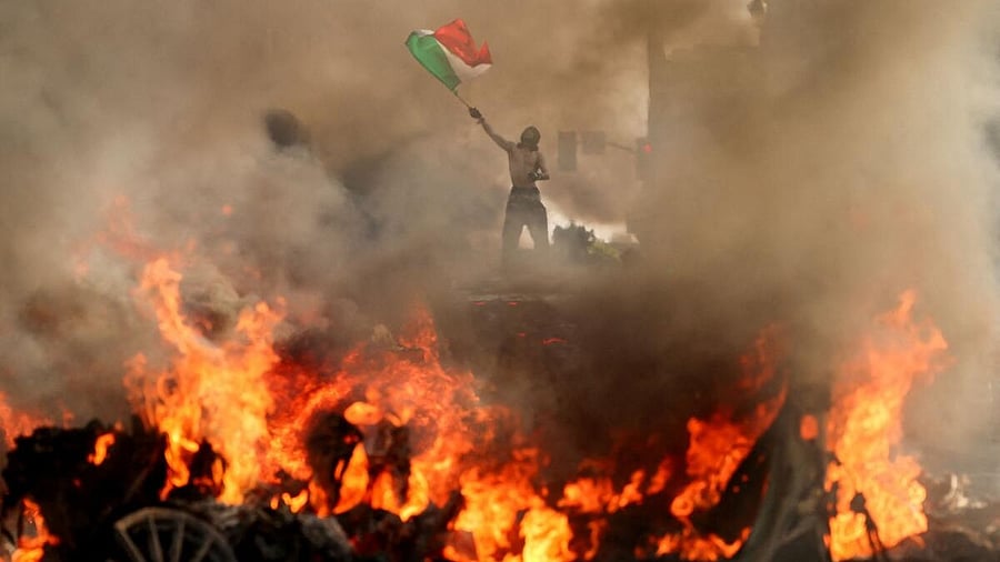 <div class="paragraphs"><p>A man waves a Mexican flag as smoke and flames rise from a burning vehicle during a protest against federal immigration sweeps, near Los Angeles City Hall, in downtown Los Angeles, California, U.S. June 8, 2025.</p></div>
