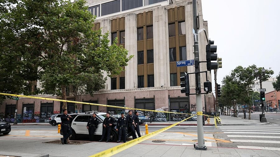 <div class="paragraphs"><p>Members of law enforcement stand next to a police car, in Los Angeles.</p></div>
