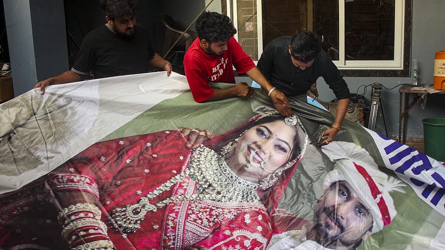 <div class="paragraphs"><p> Family members of Raja Raghuvanshi, who was allegedly murdered during his honeymoon in Meghalaya, cut out the picture of his wife Sonam Raghuvanshi from a poster of their marriage after she was accused of plotting his murder, in Indore</p></div>