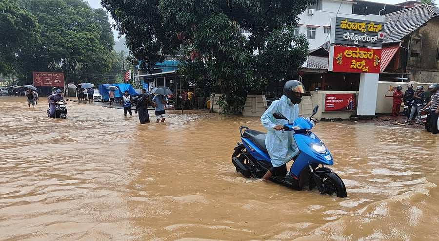 <div class="paragraphs"><p>Motorists struggle to navigate through waterlogged Geetanjali Circle in Karwar.</p></div>