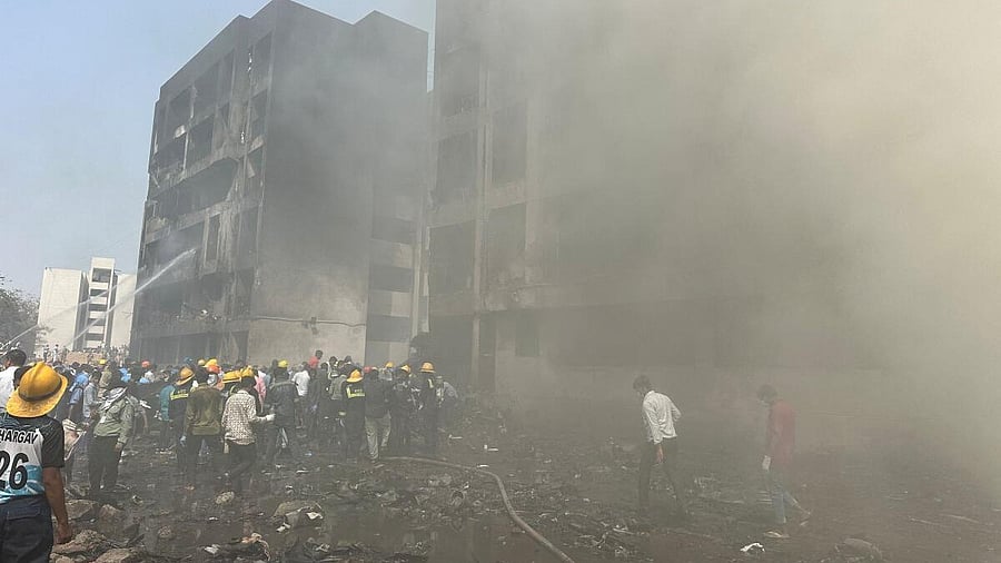 <div class="paragraphs"><p>Rescue team members work as smoke rises at the site where an Air India plane crashed in Ahmedabad.</p></div>