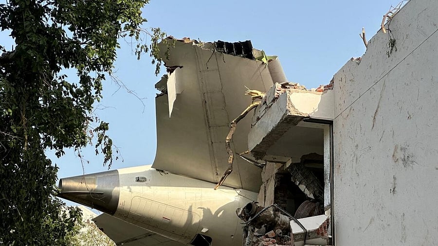 <div class="paragraphs"><p>A tail of an Air India Boeing 787 Dreamliner plane that crashed is seen stuck on a building after the incident in Ahmedabad.</p></div>