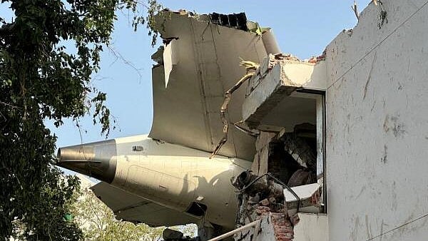 <div class="paragraphs"><p>A tail of an Air India Boeing 787 Dreamliner plane that crashed is seen stuck on a building after the incident in Ahmedabad.</p></div>