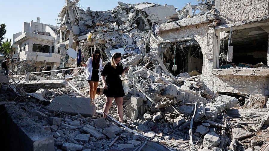 <div class="paragraphs"><p>People walk at an impact site following missile attack from Iran on Israel, in Rishon LeZion, Israel. </p></div>