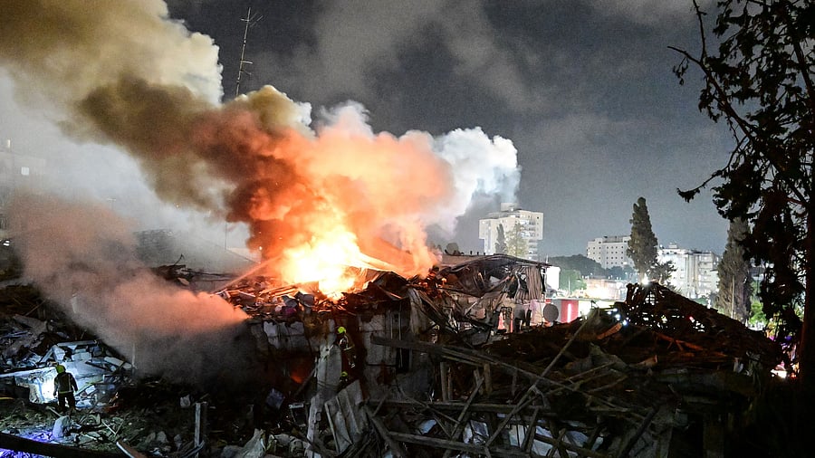 <div class="paragraphs"><p>Fire fighters work at an impact site following missile attack from Iran on Israel, at central Israel June 15, 2025.</p></div>
