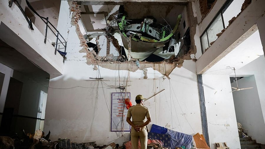 <div class="paragraphs"><p>A police officer stands in front of the wreckage of an Air India aircraft, bound for London's Gatwick Airport, which crashed during take-off from an airport in Ahmedabad</p></div>