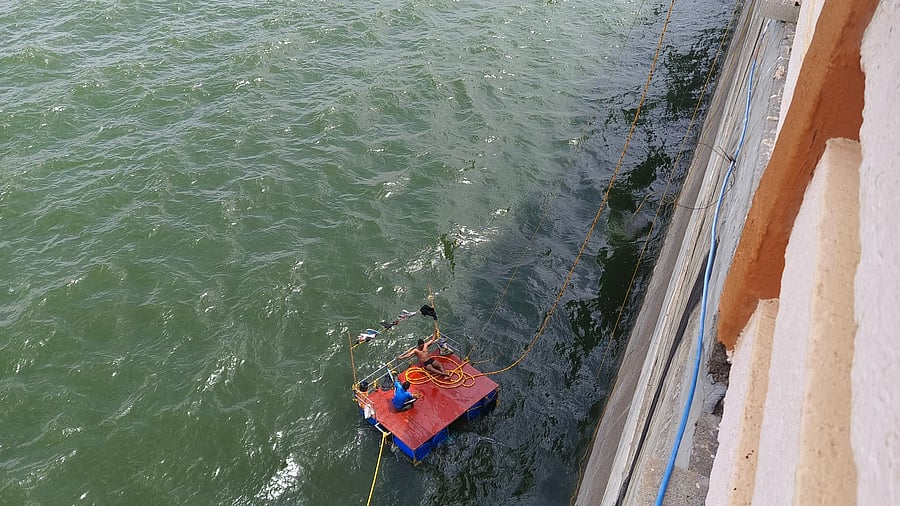Workers are lowered into the water through a platform tied to ropes so that they can undertake repair and renovation works in Almatti dam in Bagalkot district.    