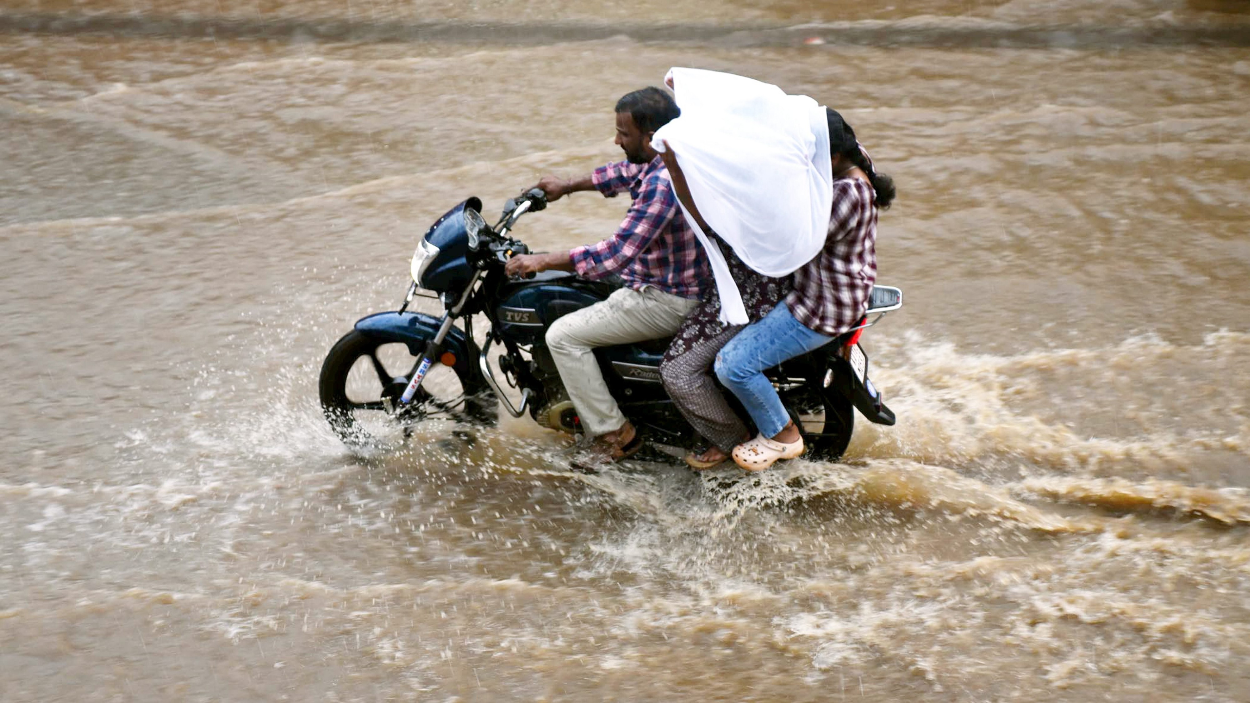 <div class="paragraphs"><p>Chikkamagaluru: Commuters move through waterlogged road during rain. </p></div>