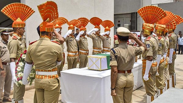 <div class="paragraphs"><p>Security personnel pay tribute to former Gujarat chief minister Vijay Rupani, who died in the Air India plane crash, during a wreath-laying ceremony outside the mortuary of a hospital in Ahmedabad.</p></div>