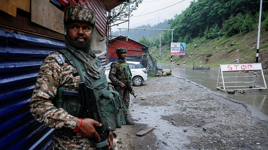<div class="paragraphs"><p>Security personnel stand guard on a road ahead of pilgrimage to Amarnath cave.</p></div>