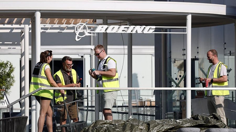 <div class="paragraphs"><p>Workers stand near a Boeing logo as they work before the opening of the 55th International Paris Airshow at Le Bourget Airport near Paris, France.</p></div>