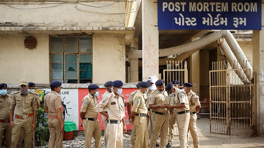 <div class="paragraphs"><p>Policemen stand guard outside the post mortem room, where the bodies of the victims who died after the Air India Boeing 787-8 Dreamliner plane bound for London's Gatwick Airport crashed during take-off from Ahmedabad have been kept, at a hospital, in Ahmedabad.</p></div>