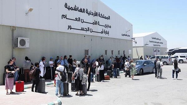 <div class="paragraphs"><p>Expats, including diplomats from different nationalities, who were stranded in West Bank and Israel, wait as they hold belongings while being evacuated through the King Hussein Bridge crossing, in South Shuna. </p></div>