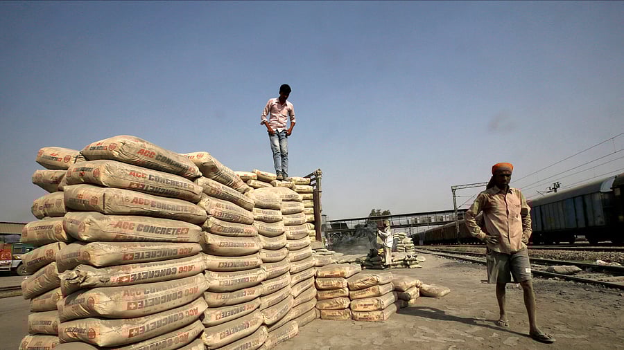 <div class="paragraphs"><p>Labourers stand after unloading cement bags from a freight train </p></div>