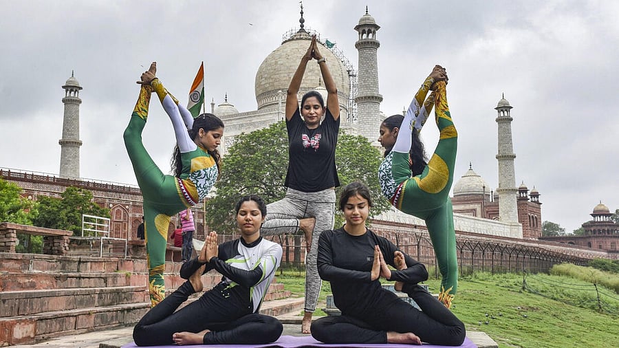 <div class="paragraphs"><p>Women perform yoga at Dussehra Ghat behind the Taj Mahal, ahead of the ‘International Day of Yoga’, in Agra, Uttar Pradesh, Friday, June 20, 2025.</p></div>