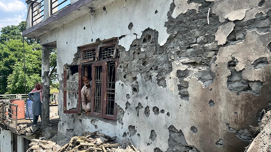 <div class="paragraphs"><p>A resident of Bhera village in Mendhar-Poonch looks out of the window of his home, damaged a day before the ceasefire. </p></div>