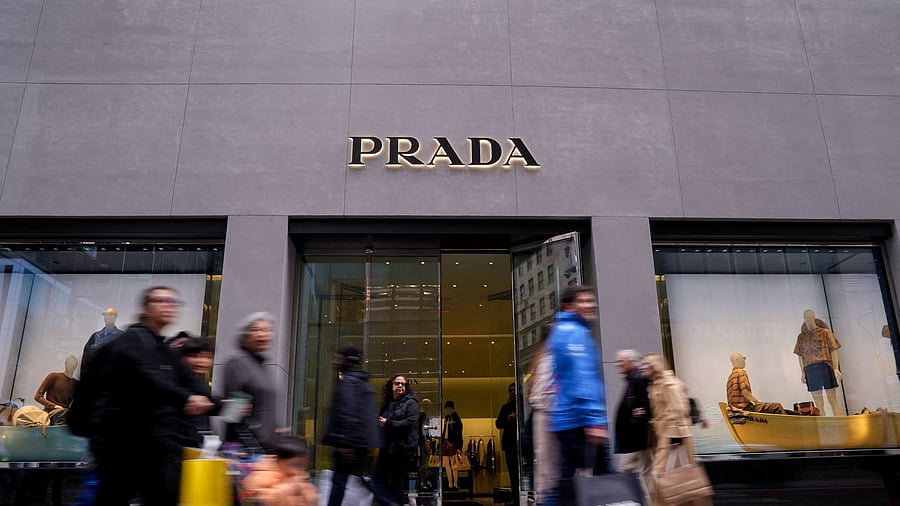 <div class="paragraphs"><p>People walk past the store of Italian luxury fashion house Prada on 5th Avenue in New York City</p></div>
