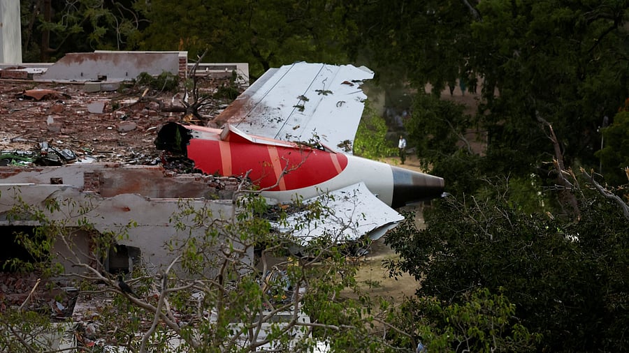 <div class="paragraphs"><p>A tail of an Air India Boeing 787 Dreamliner plane that crashed is seen stuck on a building after the incident in Ahmedabad.</p></div>