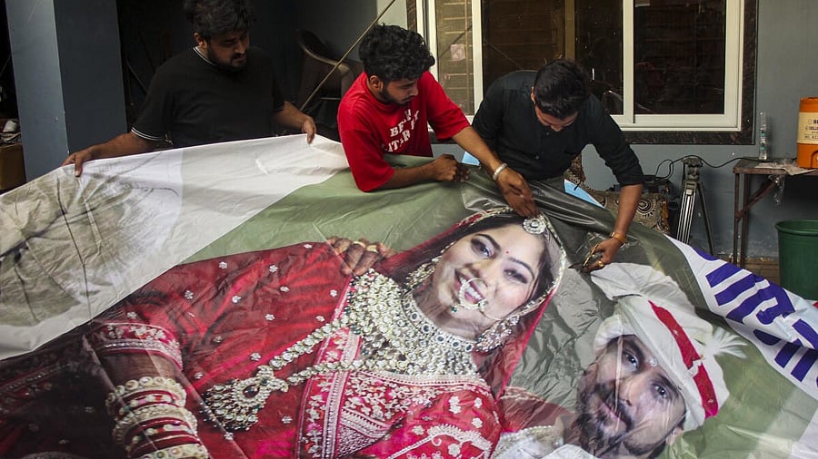 <div class="paragraphs"><p>Family members of Raja Raghuvanshi, who was allegedly murdered during his honeymoon in Meghalaya, cut out the picture of his wife Sonam Raghuvanshi from a poster of their marriage after she was accused of plotting his murder, in Indore, Tuesday, June 10, 2025.</p></div>