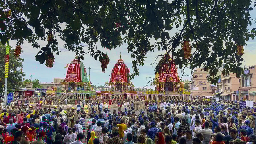 <div class="paragraphs"><p>People gather near the chariots of Lord Jagannath, Lord Balabhadra and Goddess Subhadra during the annual 'Rath Yatra' festival celebration, in Puri, Odisha.</p></div>