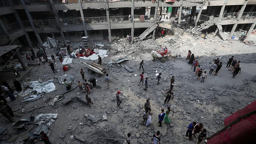 <div class="paragraphs"><p>Palestinians inspect the damage at an UNRWA school sheltering displaced people that was hit in an Israeli air strike on Sunday, in Gaza City, June 30, 2025.</p></div>