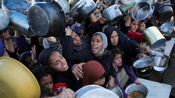 <div class="paragraphs"><p>Palestinians gather to receive food cooked by a charity kitchen, in Khan Younis</p></div>