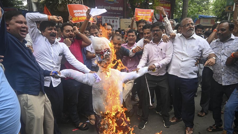<div class="paragraphs"><p>Shiv Sena (UBT) workers stage a protest by burning state government’s resolution papers of the inclusion of Hindi in the school curriculum from class 1, near Mumbai Marathi Patrakar Sangh office, in Mumbai</p></div>