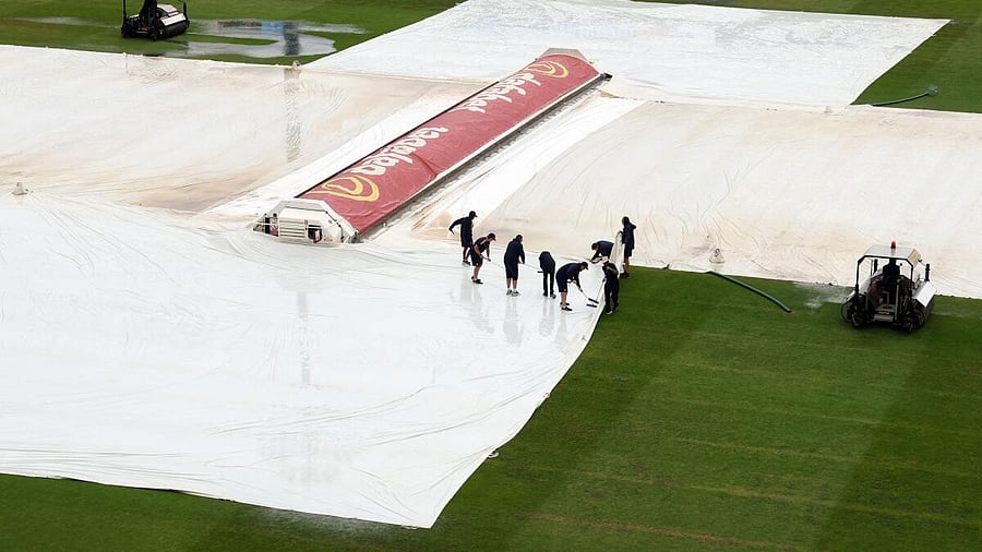 <div class="paragraphs"><p>General view inside the stadium as ground staff members pull covers due to rain.</p></div>
