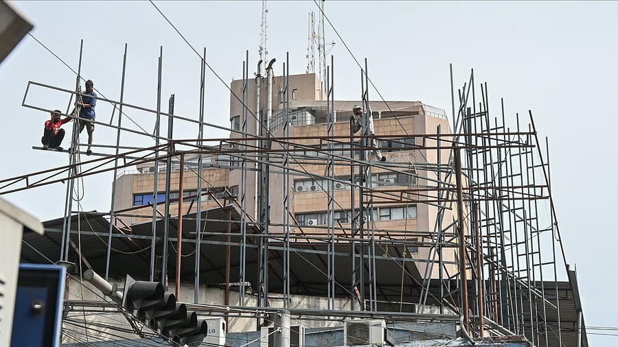 <div class="paragraphs"><p>Workers engage in construct iron structure for fixing LED advertisement holder at Shoolay circle in Bengaluru on Monday, 30th June 2025.</p></div>
