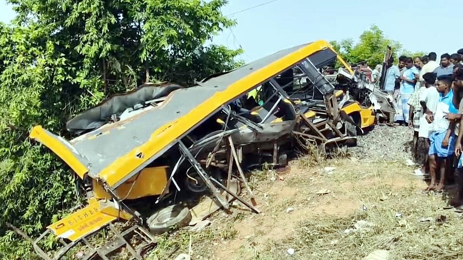 <div class="paragraphs"><p>People gather near the wreckage of a vehicle after a school van was allegedly hit by a passing train while attempting to cross a railway track, in Cuddalore</p></div>