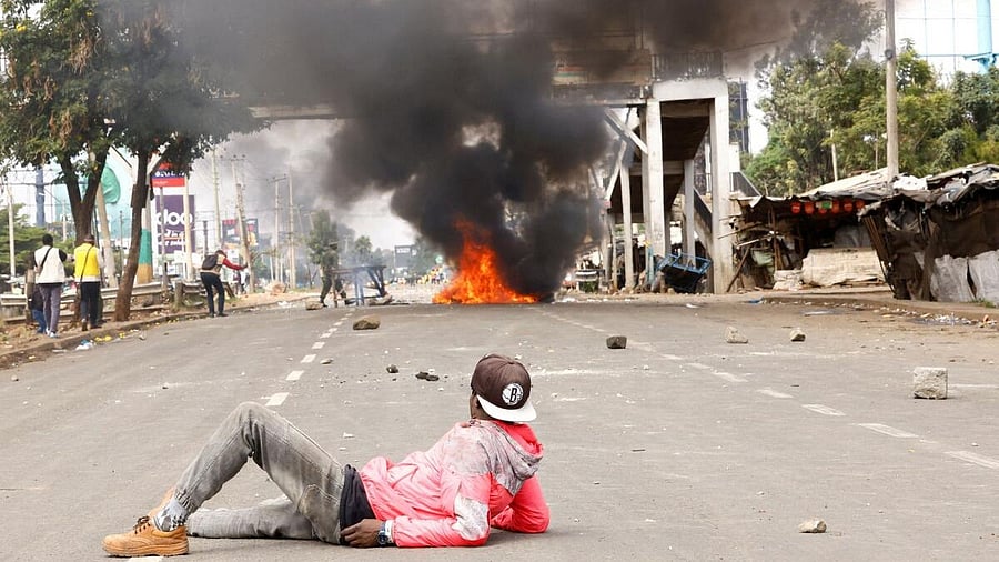 <div class="paragraphs"><p>A demonstrator lies on the road, watching clashes with police as a fire burns, at the "Saba Saba People's March" anti-government protest in Nairobi, Kenya July 7, 2025.</p></div>