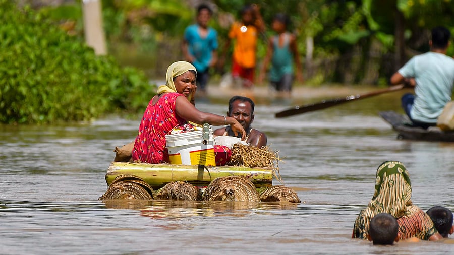 <div class="paragraphs"><p>People use a banana raft to travel as they shift to a safer place from a flood-affected area, at Dighal Jarani village in Hojai district, Assam, Tuesday, July 8, 2025.</p></div>