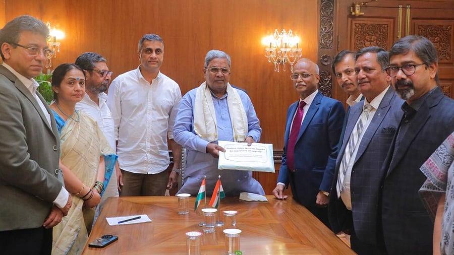 Justice Michael D’Cunha submits a report on the stampede at Chinnaswamy Stadium, to Chief Minister Siddaramaiah, in Bengaluru on Friday. 