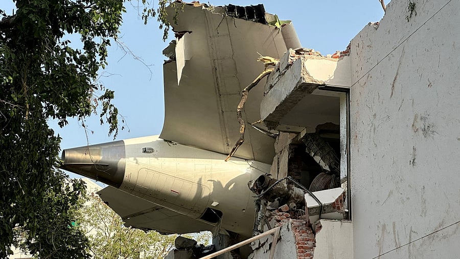 <div class="paragraphs"><p>A tail of an Air India Boeing 787 Dreamliner plane that crashed is seen stuck on a building after the incident in Ahmedabad. </p></div>