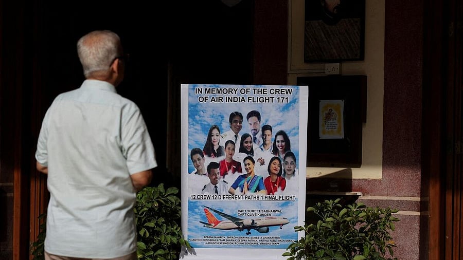 <div class="paragraphs"><p>A man prays in front of a placard during a memorial held for the deceased crew members of the Air India Boeing 787-8 Dreamliner plane, which crashed during take-off from an airport in Ahmedabad</p></div>