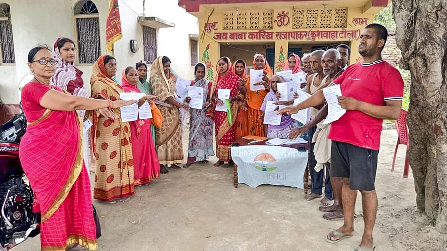 <div class="paragraphs"><p>Voters show the enumeration forms given by a Booth Level Officer (BLO) during the ongoing special intensive revision of electoral rolls in Bihar</p></div>