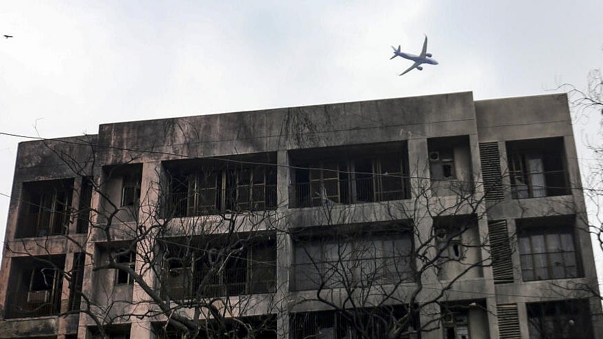 <div class="paragraphs"><p>An aircraft flies over one of the buildings damaged by the AI 171 crash.</p></div>