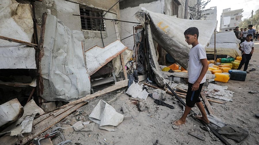 <div class="paragraphs"><p>A Palestinian boy inspects the site of an Israeli strike that killed Palestinians, gathered to collect water from a distribution point, according to medics, in Nuseirat in the central Gaza Strip July 13, 2025.</p></div>