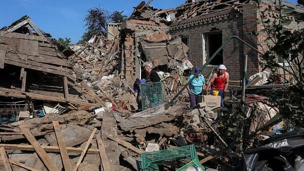 <div class="paragraphs"><p>Residents collect things from their destroyed building hit by a Russian drones.</p></div>