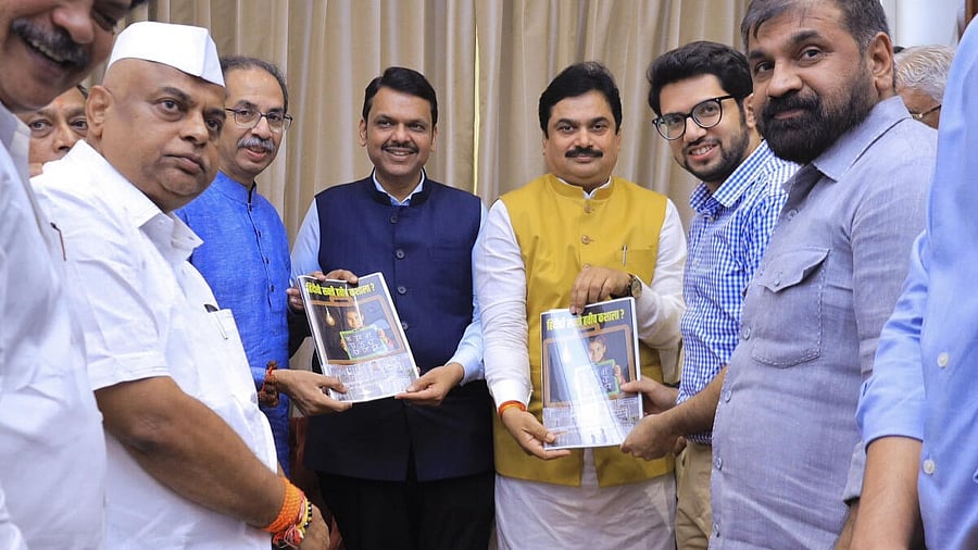 <div class="paragraphs"><p>Maharashtra Chief Minister Devendra Fadnavis being presented a compiled book ‘Why Do We Need Hindi?’ by Shiv Sena (UBT) chief Uddhav Thackeray and party leaders, in Mumbai</p></div>