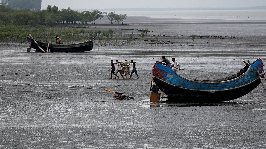 Fishermen carry a fishing net at the bank of Naf river, in Teknaf area of Cox's Bazar, Bangladesh, June 24, 2024. REUTERS/Mohammad Ponir Hossain