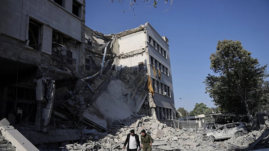 <div class="paragraphs"><p>Men walk among debris, after powerful airstrikes shook Damascus on Wednesda.</p></div>