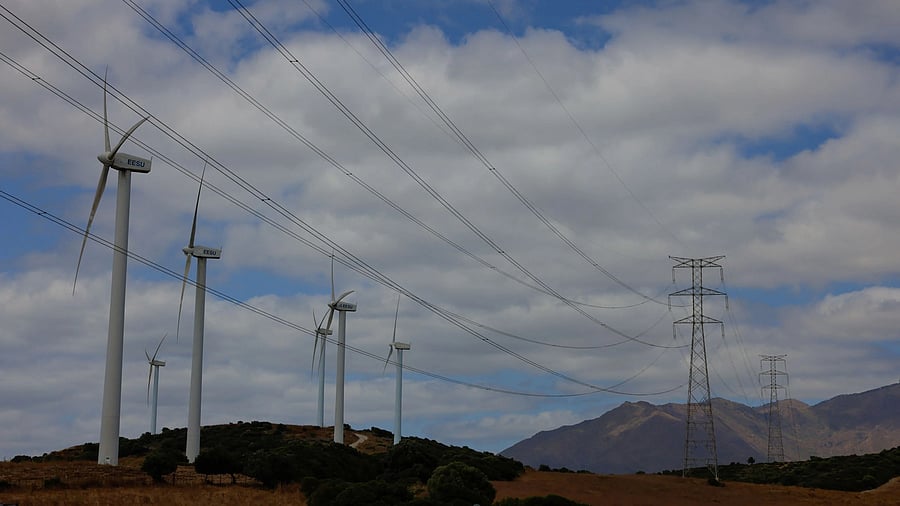 <div class="paragraphs"><p>Wind turbines spin next to power lines connecting pylons of high-tension electricity, near Casares, Spain, July 12, 2025. </p></div>