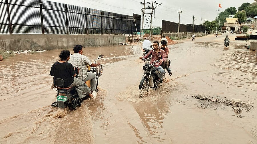 <div class="paragraphs"><p>Motorcyclists navigate flooded road in Raichur on Monday.&nbsp;</p></div>