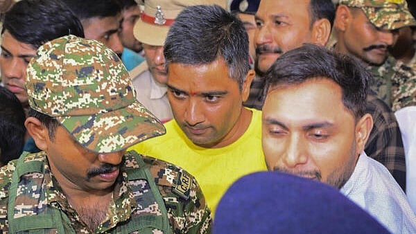 <div class="paragraphs"><p>Security personnel and others escort Chaitanya Baghel, in yellow, son of senior Congress leader and former Chhattisgarh chief minister Bhupesh Baghel.</p></div>