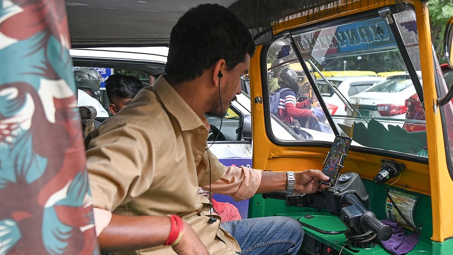 <div class="paragraphs"><p>An autorickshaw driver uses an app to track customers. </p></div>