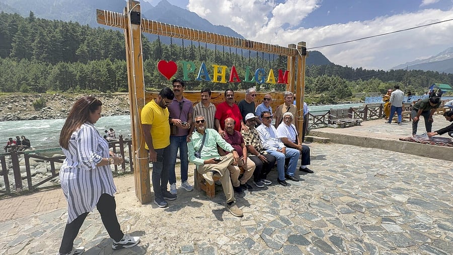 <div class="paragraphs"><p>Tourists pose for a photograph as they visit Pahalgam, in Anantnag district.</p></div>