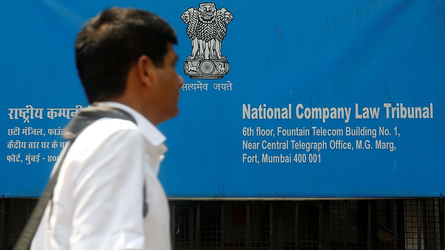<div class="paragraphs"><p>A man walks past a signboard of the National Company Law Tribunal (NCLT) outside it's office in Mumbai.</p></div>