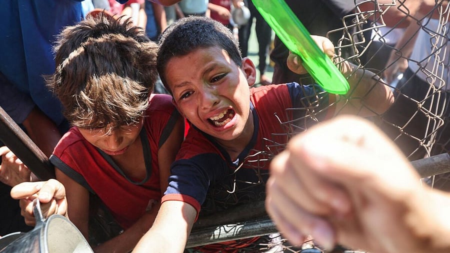 <div class="paragraphs"><p>Palestinians gather to receive food from a charity kitchen, amid a hunger crisis, in Nuseirat, central Gaza Strip.</p></div>