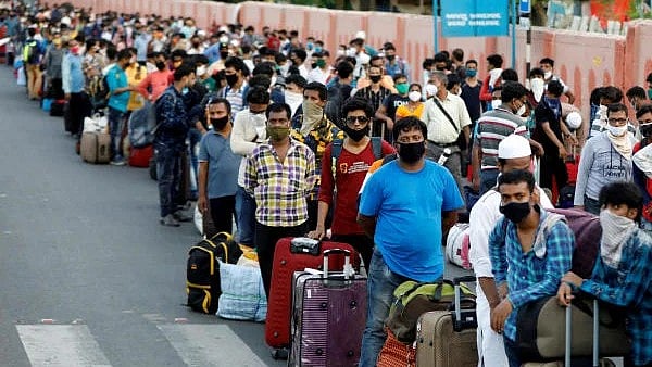 <div class="paragraphs"><p>Migrant workers and their families wait in lines outside a railway station to board a train.</p></div>